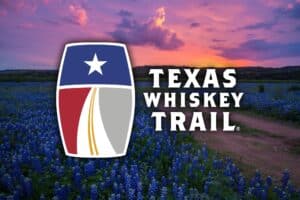 sunset over bluebonnet field with a logo in the middle